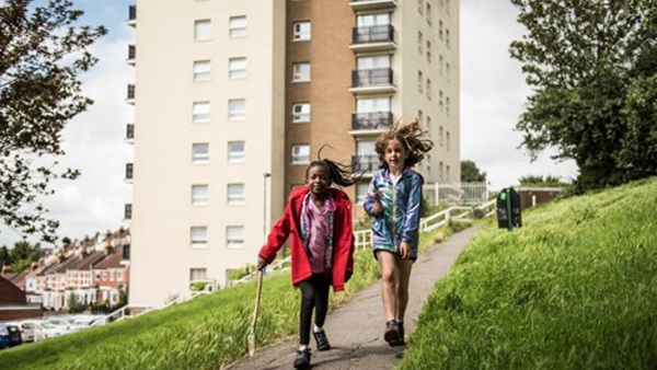 Young children walking past a tower block