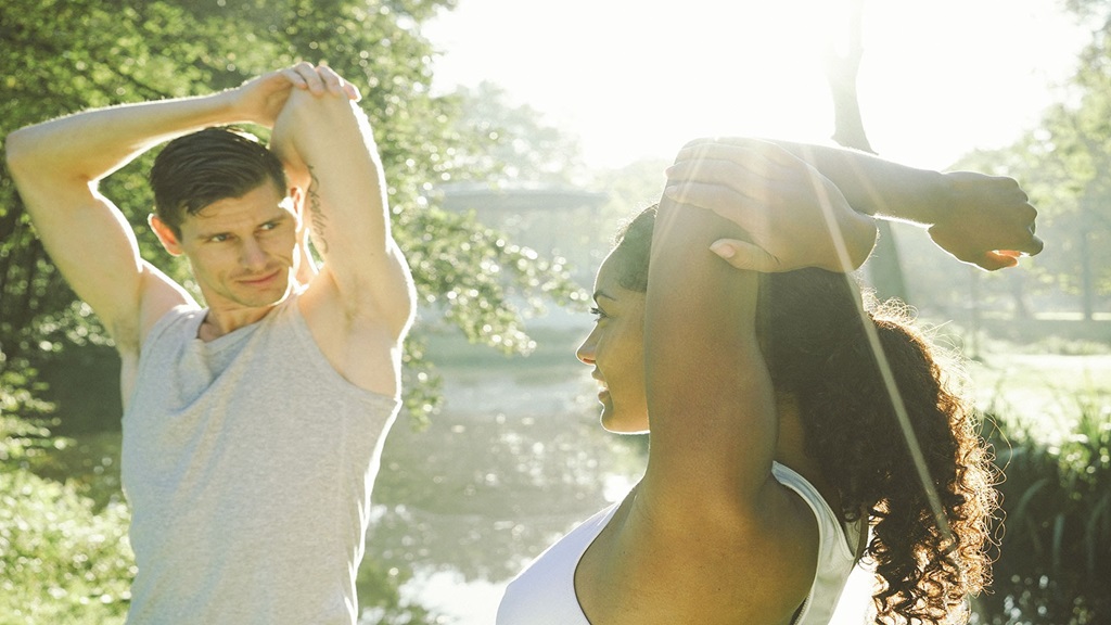 Couple stretching after a workout in an outdoor setting